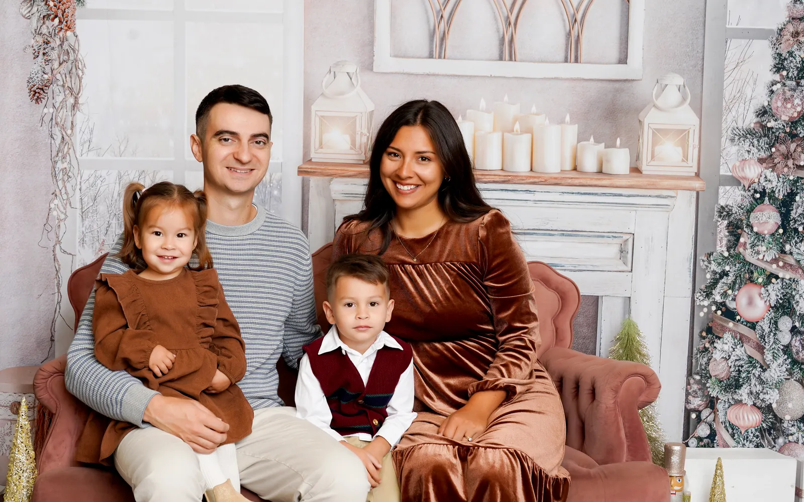 A family of four on the pink velvet settee of the Sugarplum Christmas set