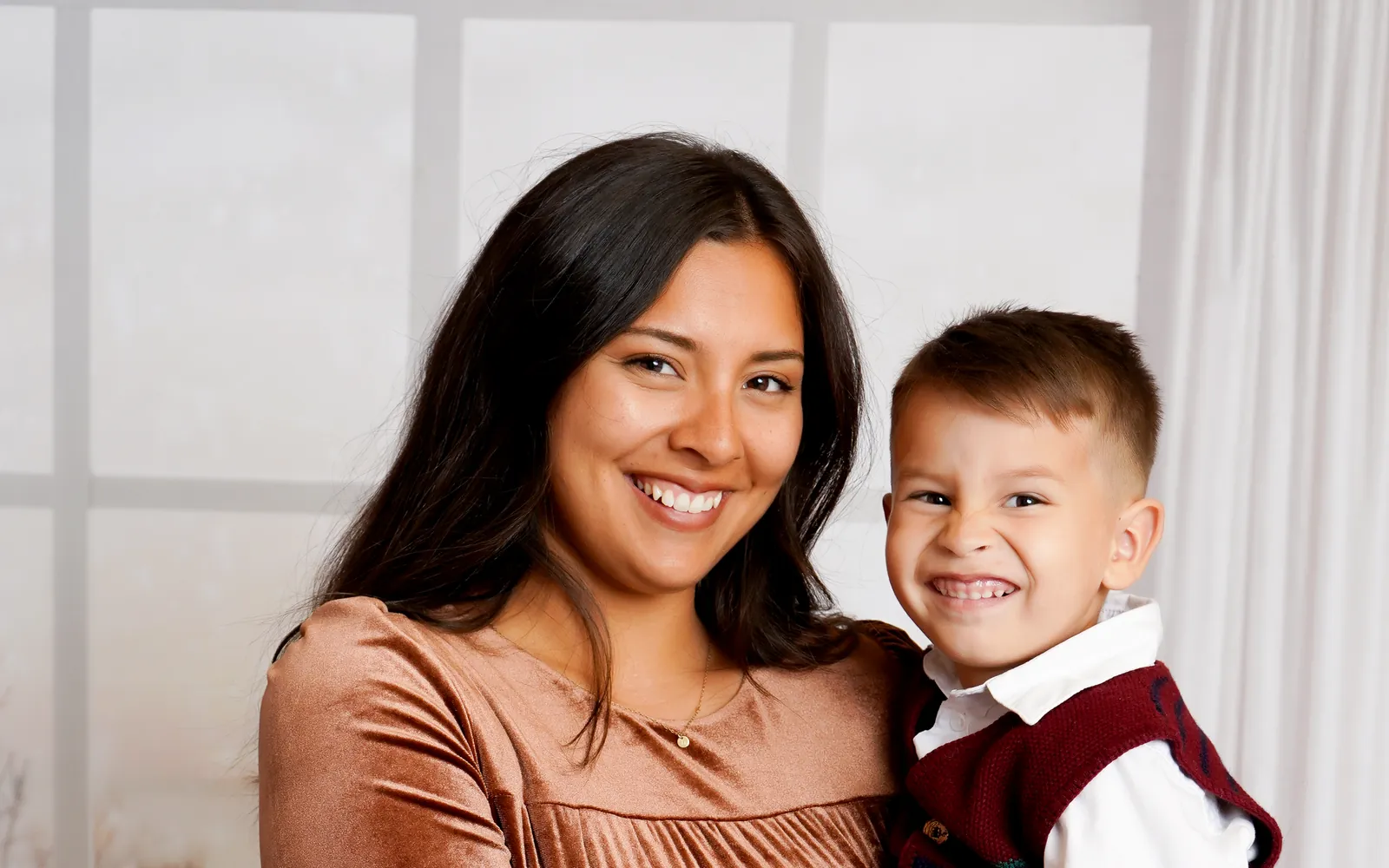 A mom holding her son by the snowy Winter Window at LaLa Holiday HQ